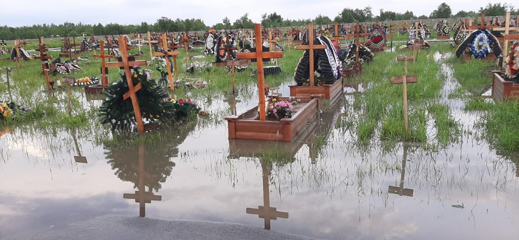 Могили та хрести у воді: у Івано-Франківську злива затопила міське кладовище