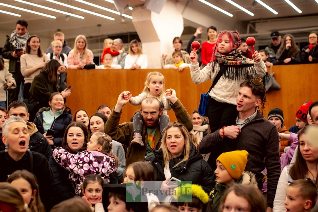 Група людей на заході з дітьми на плечах