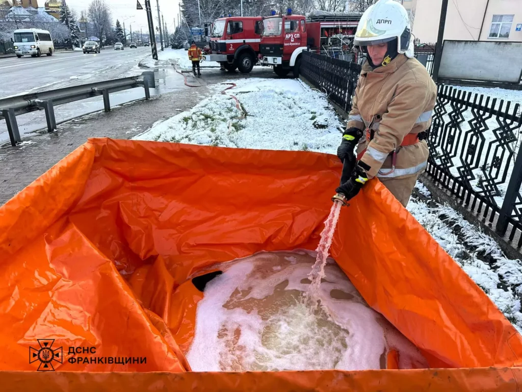 Рятувальник гасить пожежу в зимових умовах.