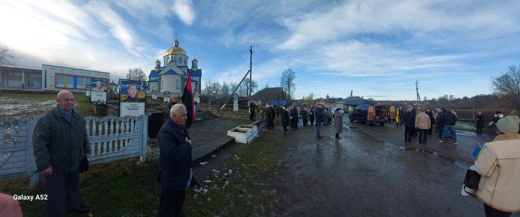 Мітинг на тлі церкви та портретів героїв