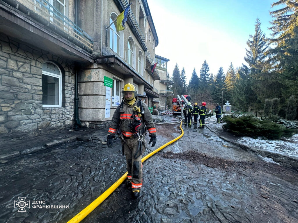 Пожежники біля будівлі з пожежним обладнанням