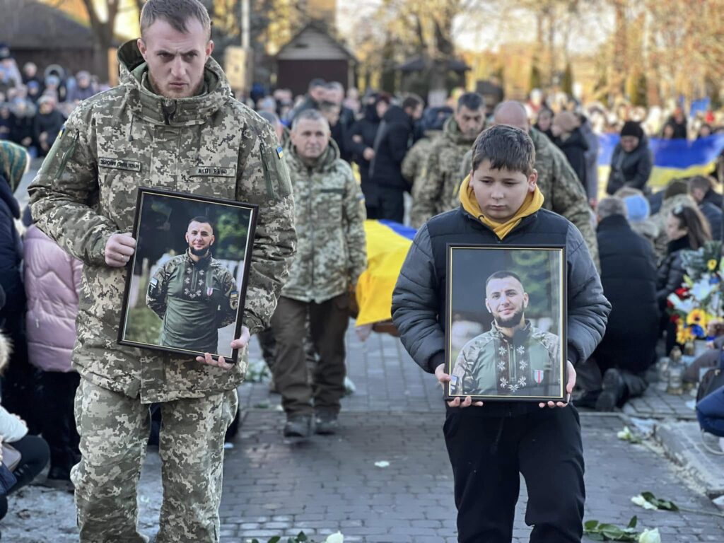 Церемонія з портретами військового в Україні.