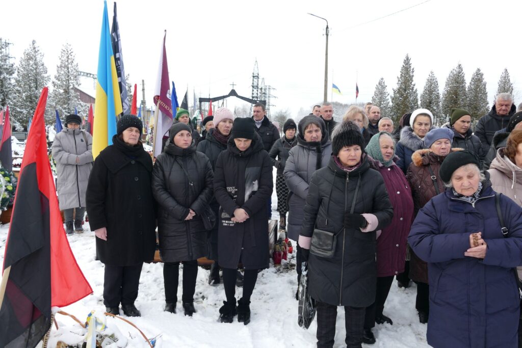 Люди на вулиці, тримають прапори, зима.