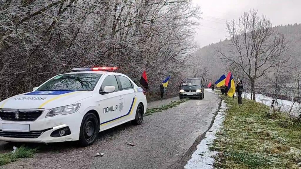 Поліцейський автомобіль і прапори на зимовій дорозі