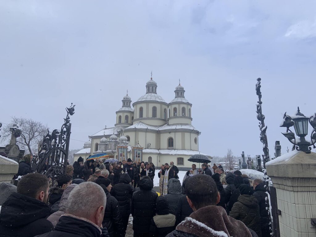 Люди зібралися біля церкви взимку