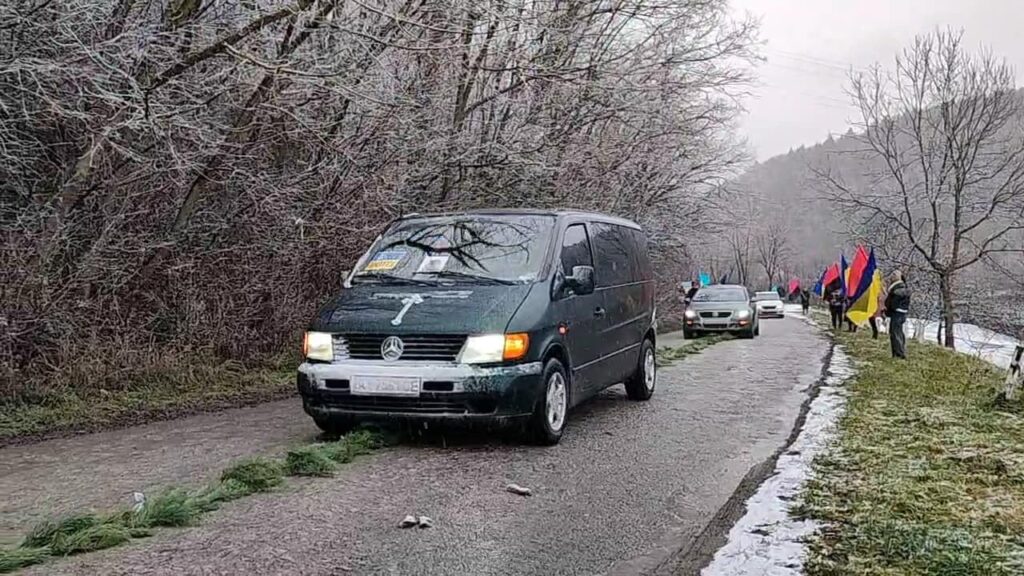 Автомобілі з прапорами на засніженій дорозі