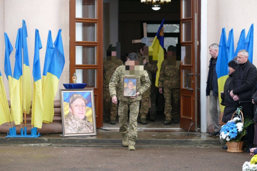 Церемонія прощання з військовим, прапори України, люди.