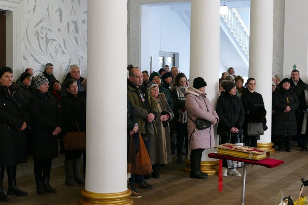 Група людей в приміщенні під час зборів.