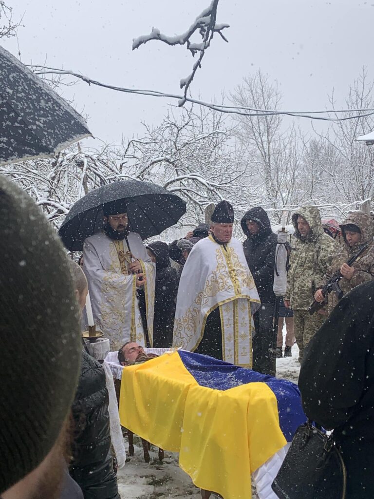 Зимова церемонія похорону під снігом в Україні.