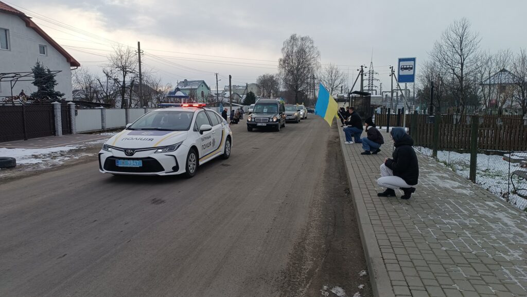 Автокортеж поліції на зимовій дорозі села.