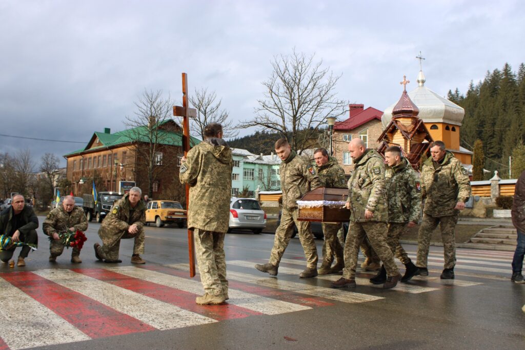 Військові переносять труну біля церкви в Україні