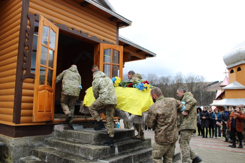 Військові несуть труну в церкву під час похорону.