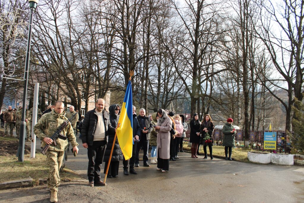 Люди з українським прапором у парку