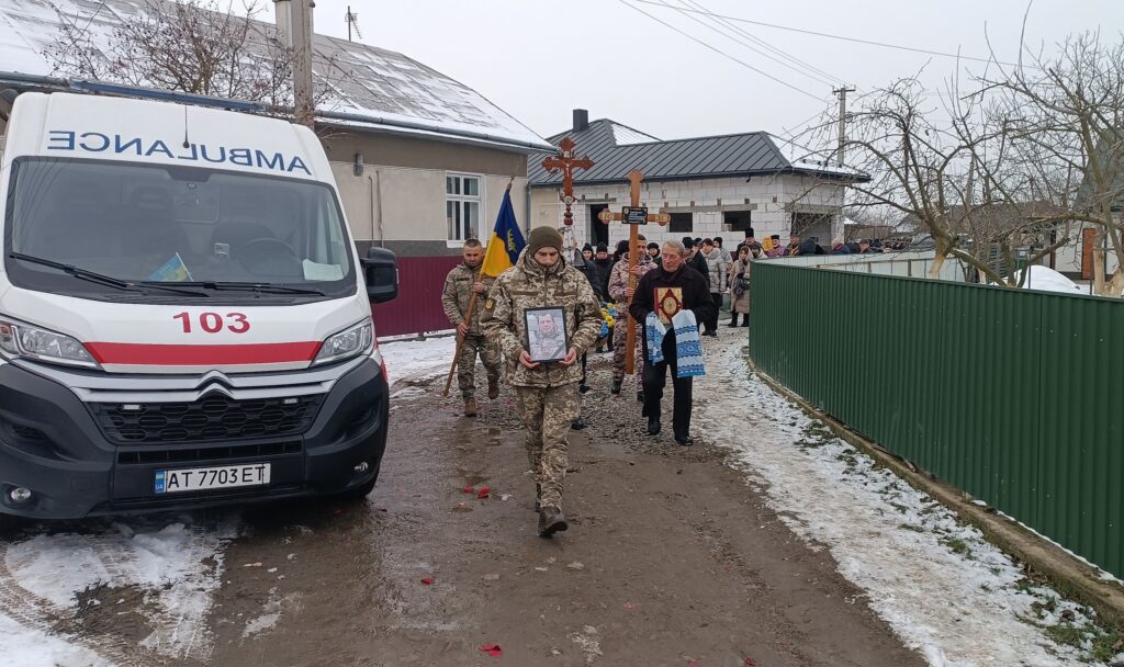 Похоронна процесія біля автомобіля швидкої допомоги