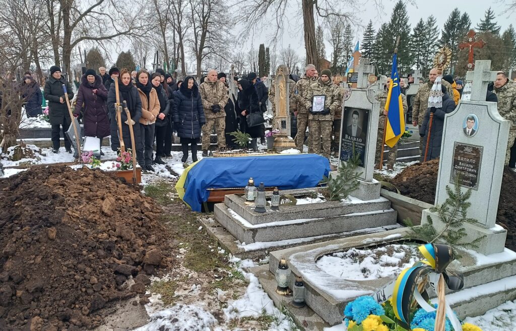 Поховання з військовими та прапором України взимку.