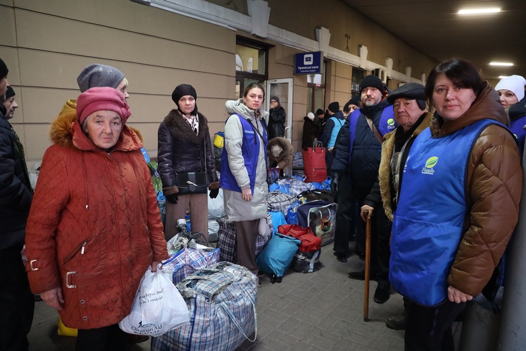 Волонтери допомагають людям з гуманітарною допомогою.