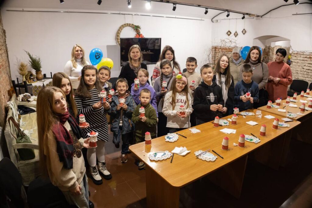 Діти з паперовими виробами на святковій зустрічі.