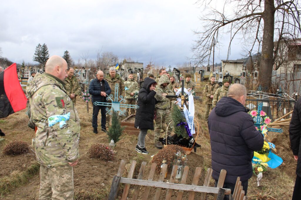 Військові та люди на цвинтарі під час церемонії.