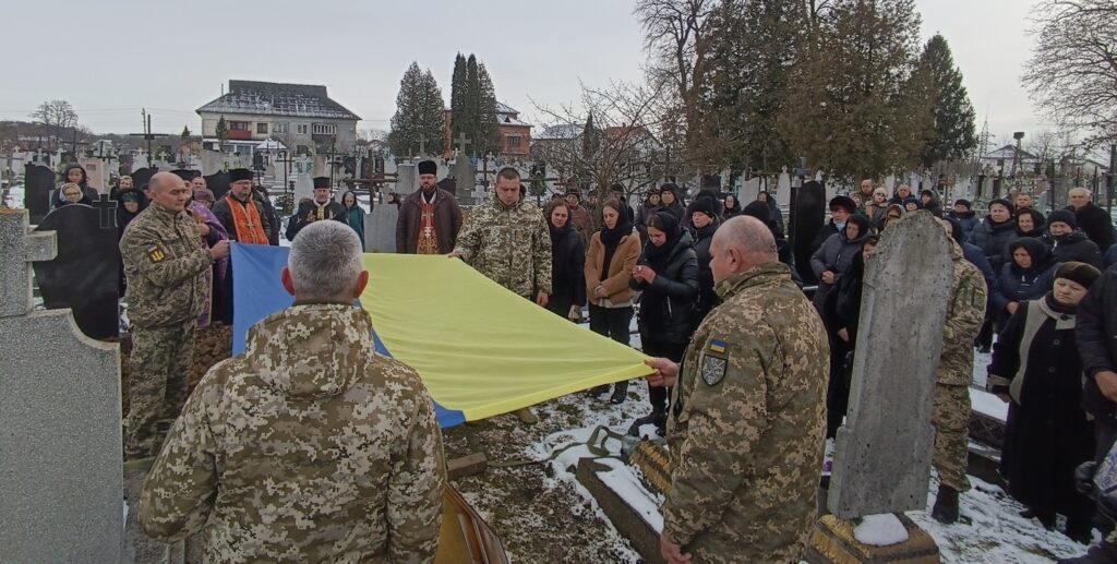 Українські військові на похороні з прапором України.