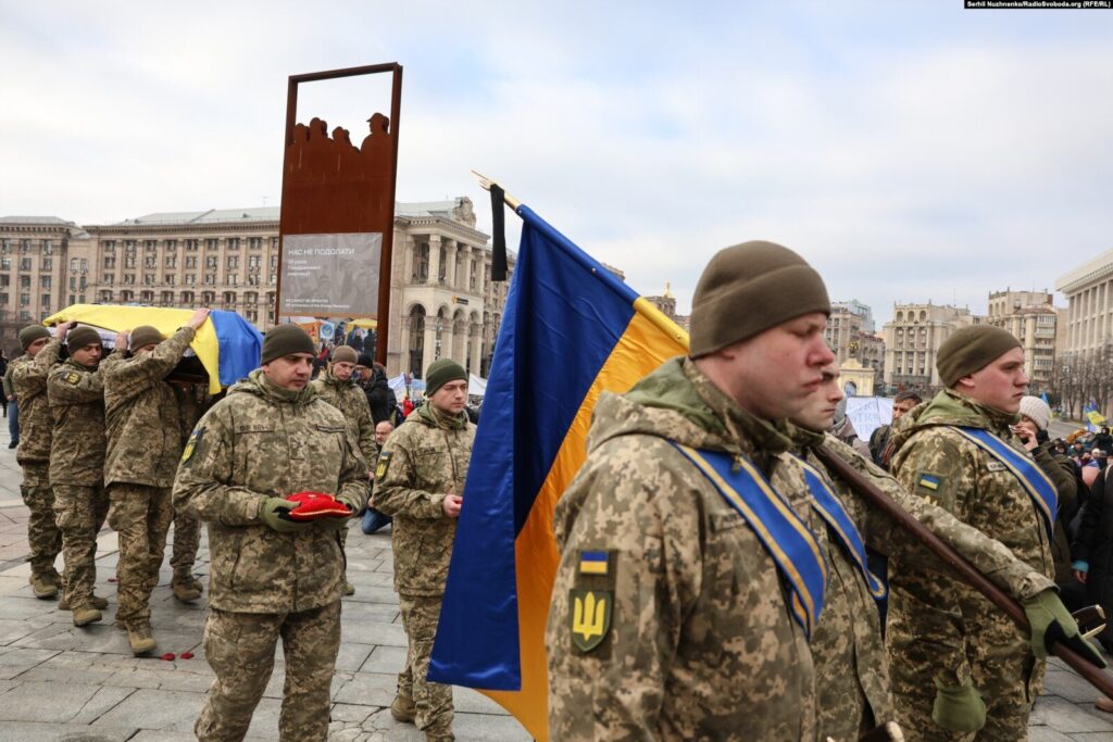 Військові несуть прапор на площі Києва.