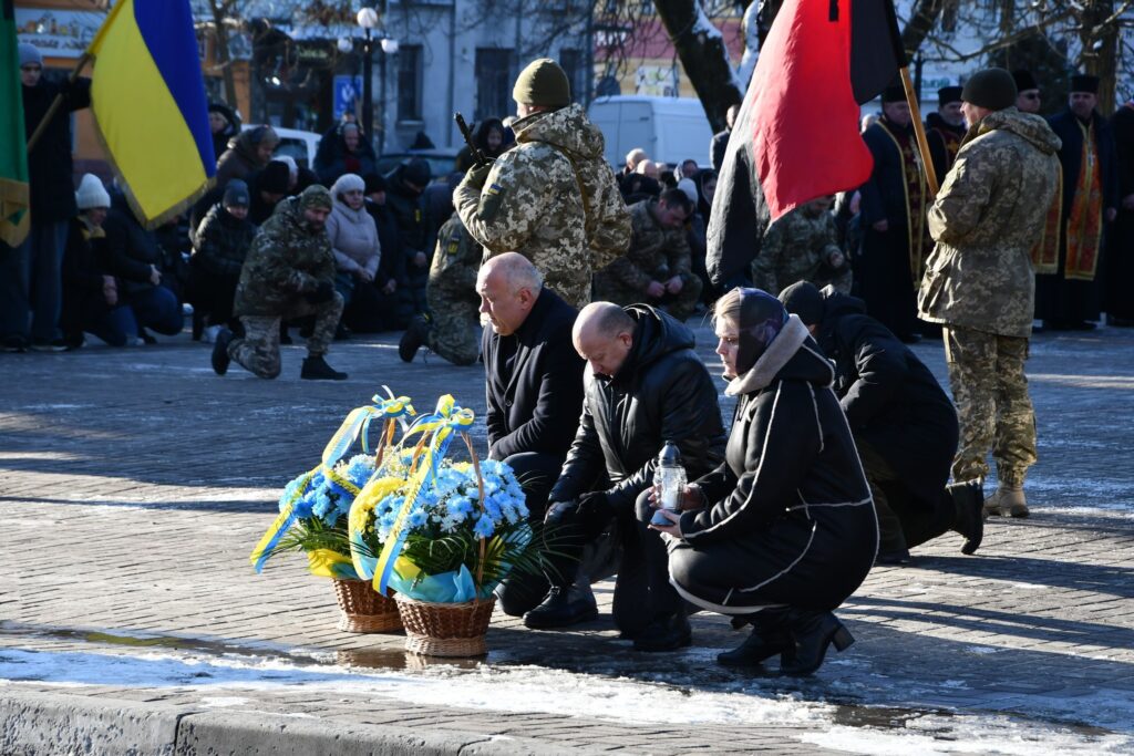 Люди вшановують пам'ять на меморіальному заході в Україні.