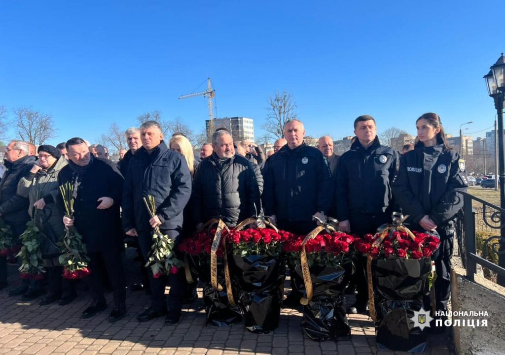 Люди вшанують пам'ять на церемонії покладання квітів.