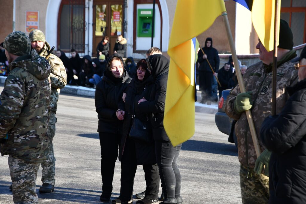 Люди під час церемонії з жовто-синіми прапорами