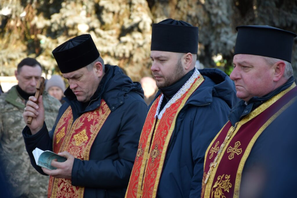 Українські священики моляться на відкритому повітрі.