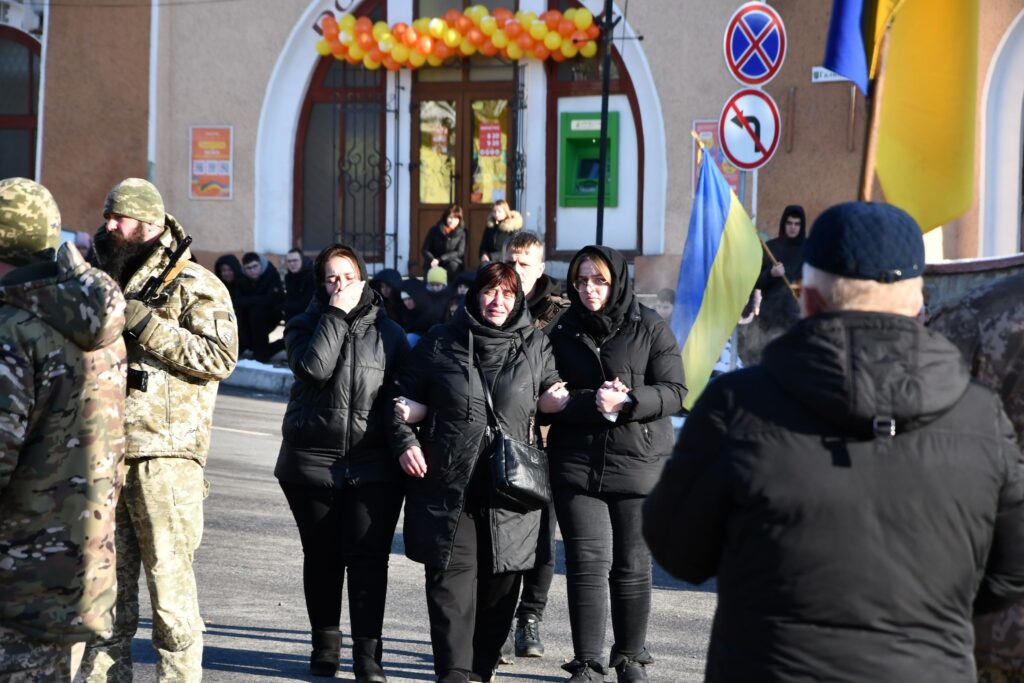 Люди на вулиці з прапорами України.