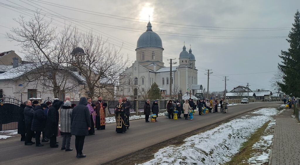 Люди біля церкви взимку на вулиці.