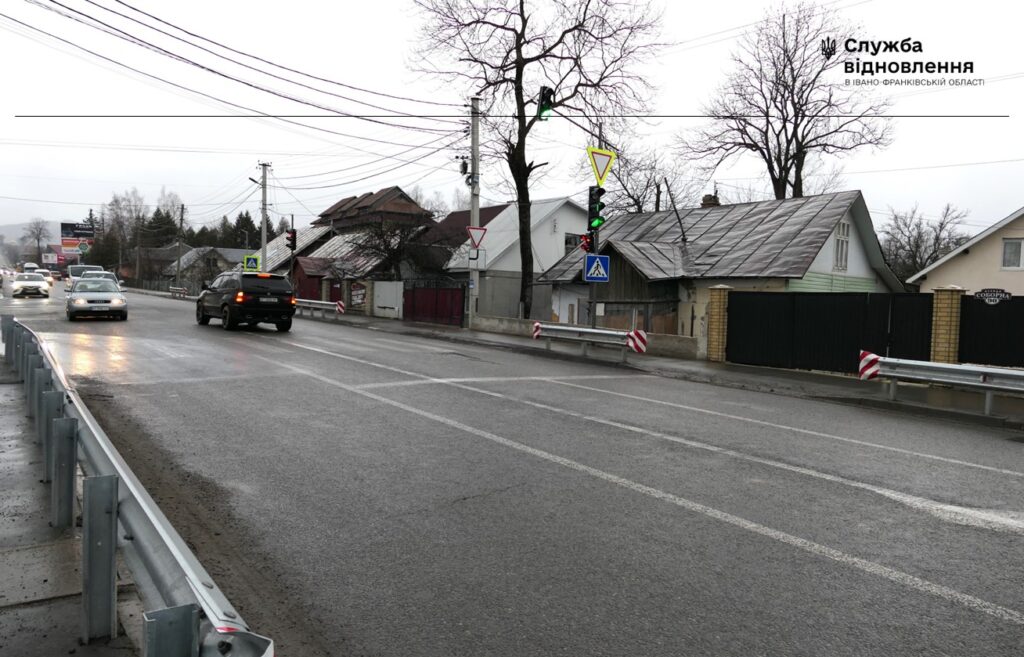 Дорога з автомобілями і пішохідним переходом в дощ.