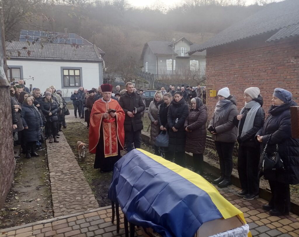 Священник на церемонії з українським прапором