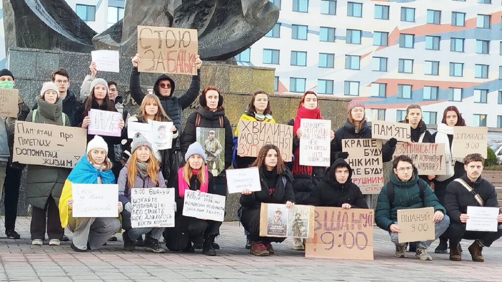 Люди на протесті з плакатами в парку