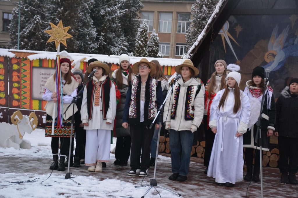 Діти у народних костюмах співають колядки на вулиці