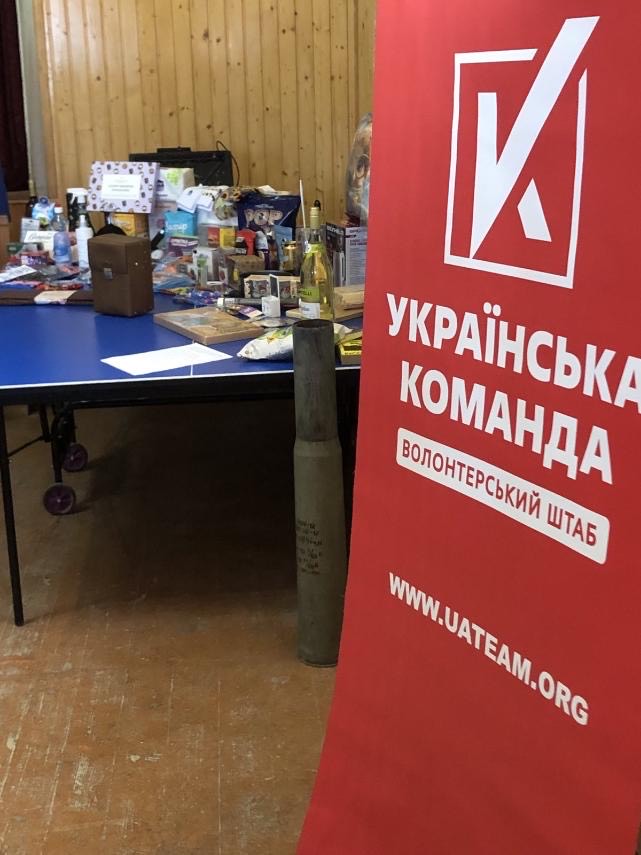 Українська команда, волонтерський штаб, стіл з товарами