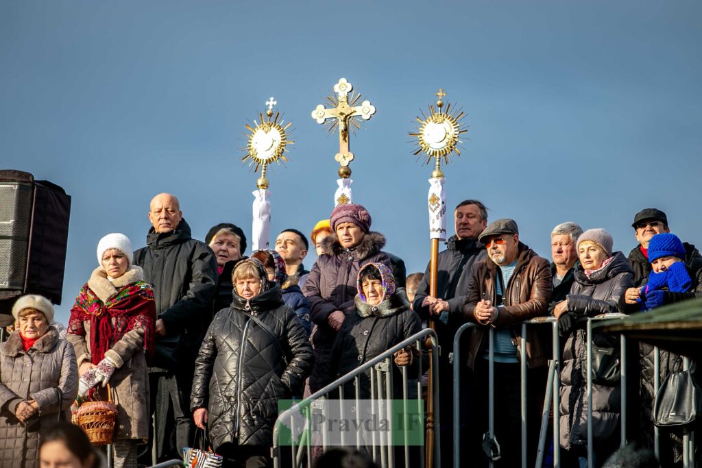 Люди на релігійному заході з хрестами та дарами.