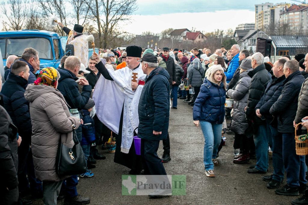 Священник освячує паски на вулиці.