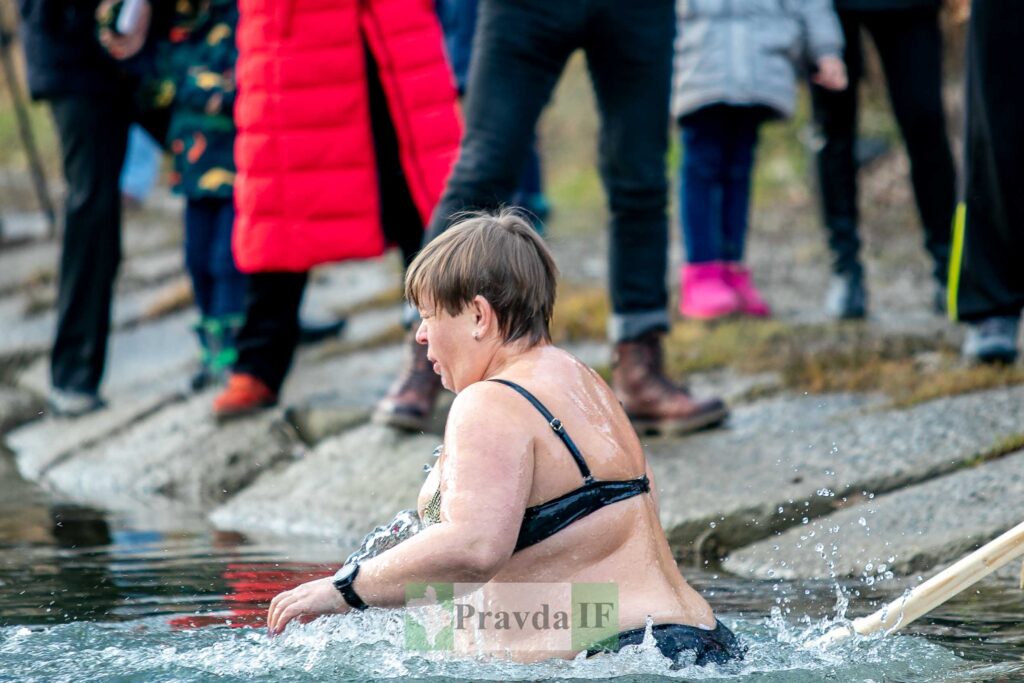 Жінка купається в холодній водоймі взимку