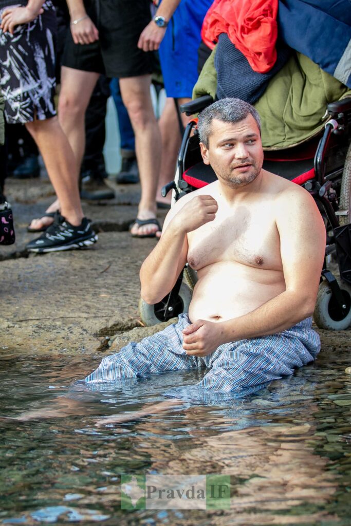 Чоловік біля води у плавках на інвалідному візку.