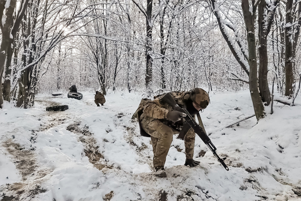 Військовий в зимовому лісі з автоматом