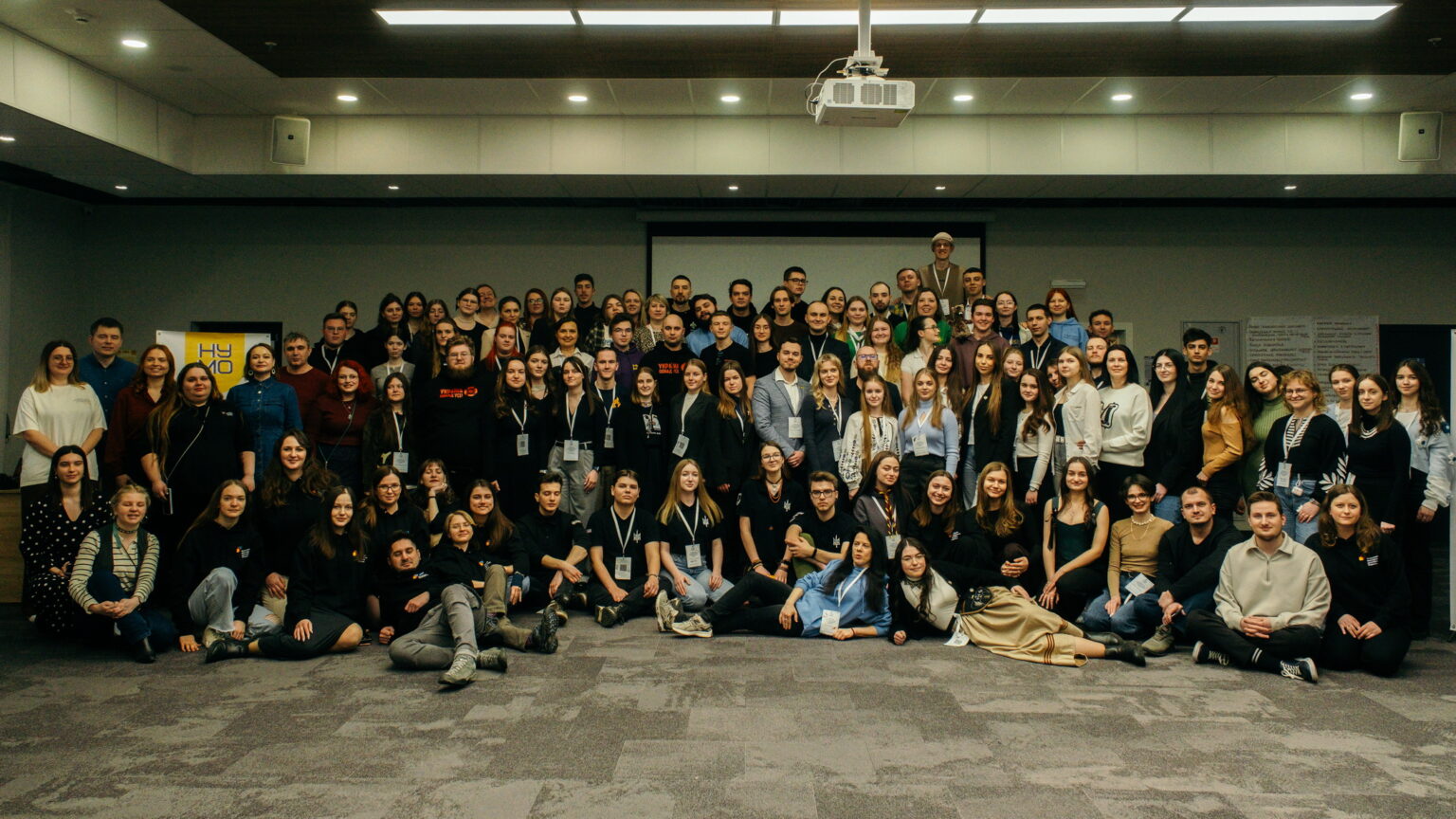 Велика група людей на конференції в залі.