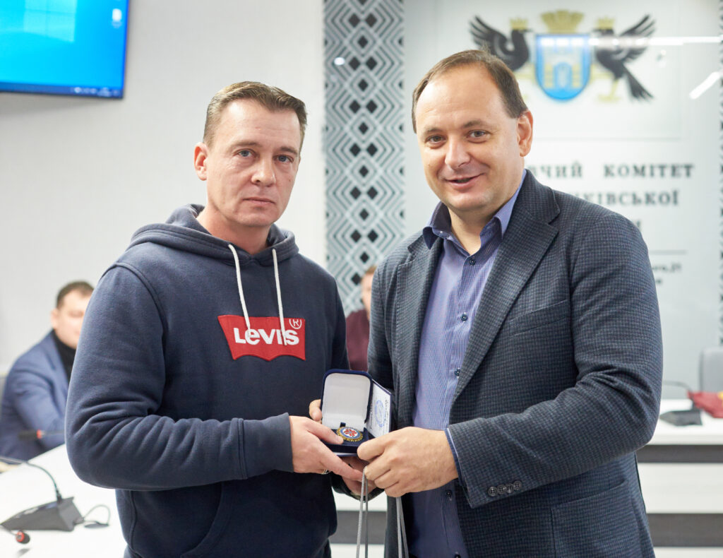 Чоловіки тримають нагороду у приміщенні офісу.