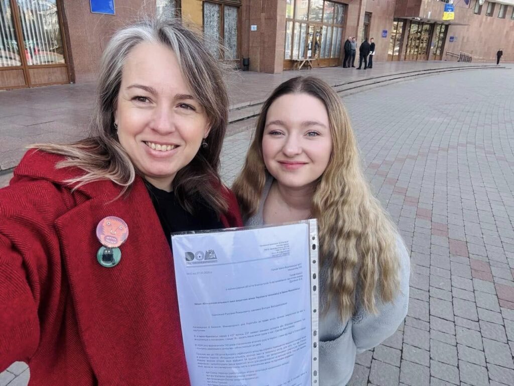 Дві жінки з документом на вулиці.