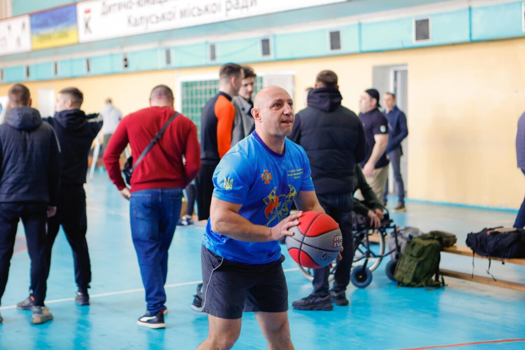 Чоловік грає в баскетбол у залі.