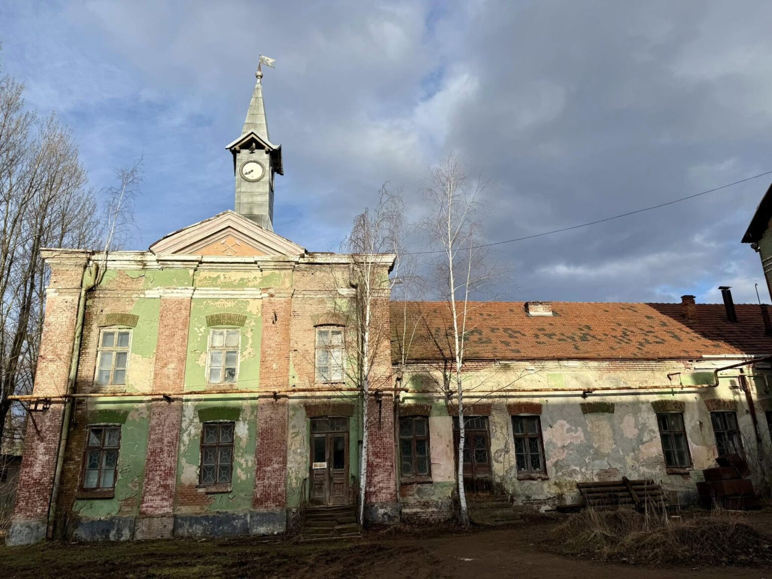 Старовинна будівля з вежею та годинником на фасаді.