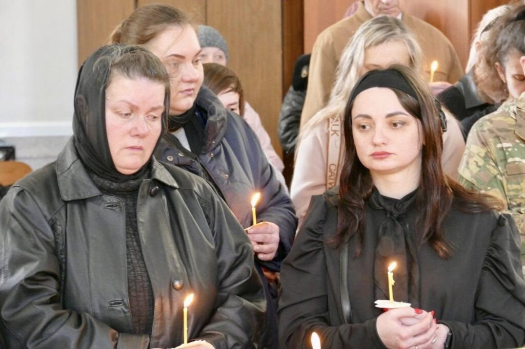 Люди з запаленими свічками в церкві