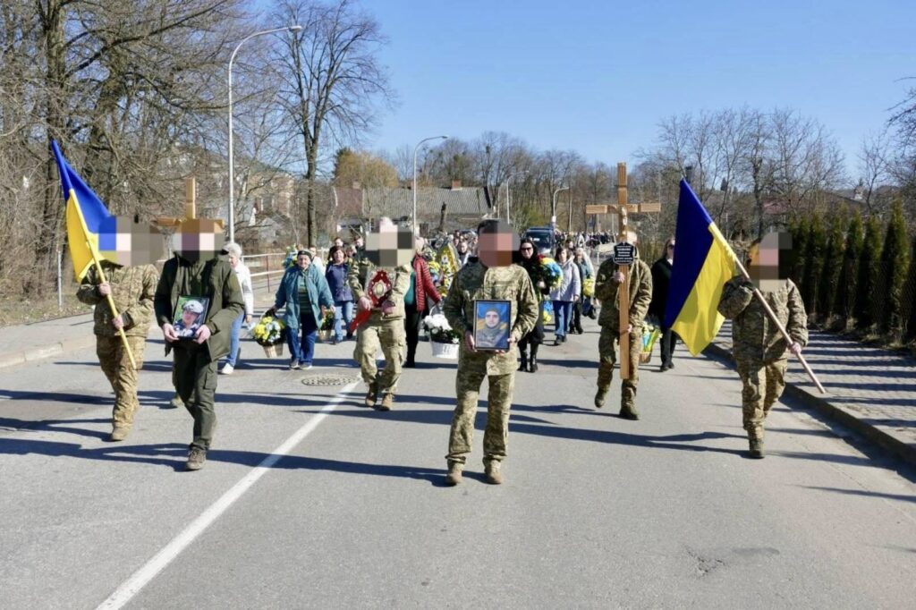 Похоронна процесія з українськими прапорами на вулиці