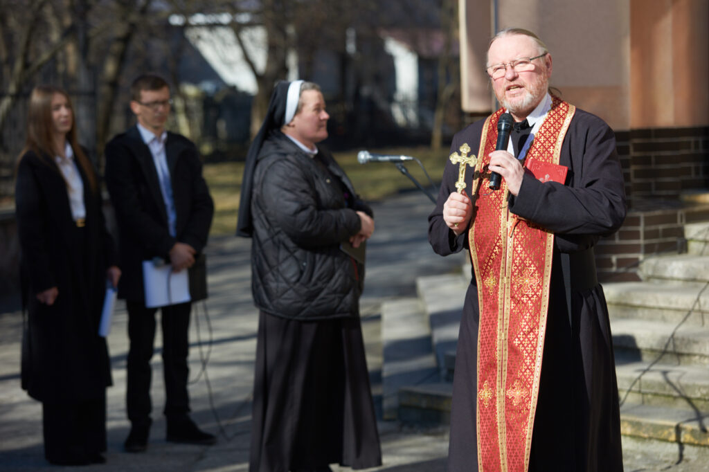 Священник тримає хрест на вуличній церемонії