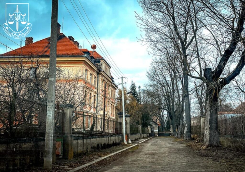 Стара будівля біля доріжки з деревами