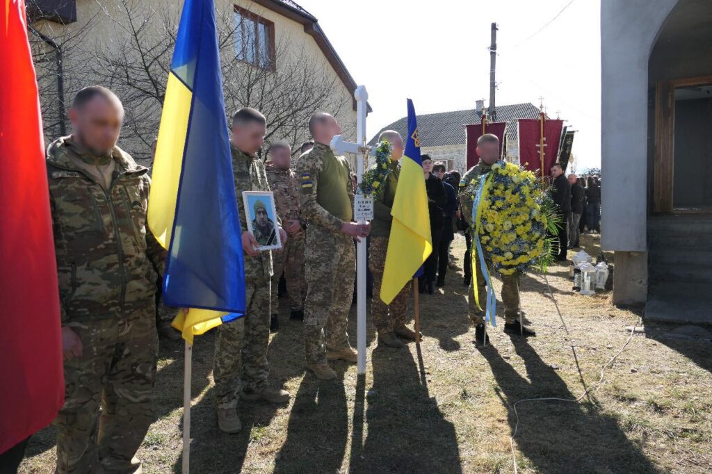 Військові церемонії з прапорами та вінками на вулиці.